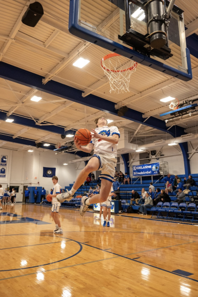 Senior Brayden Moeves (1) gracefully dunks during warmups before the scrimmage.